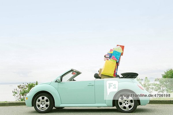 Convertible car with shopping bags in backseat