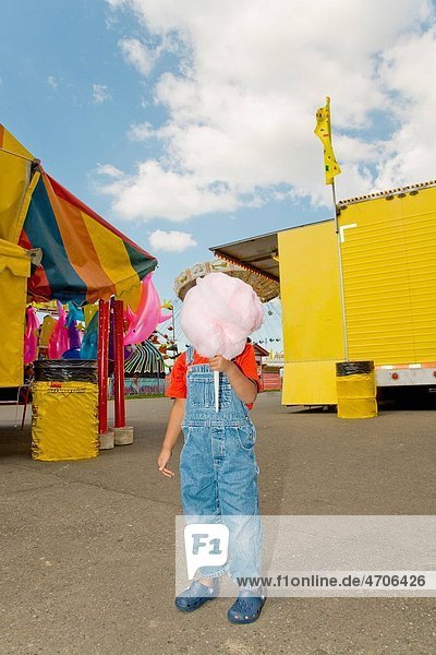 Boy holding cotton candy in front of face
