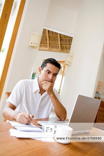 Man working on a laptop and preparing home finance budget