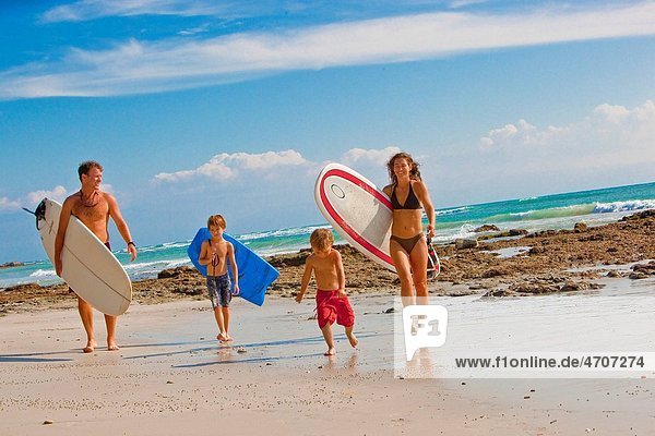 family with surboards on beach in mexico