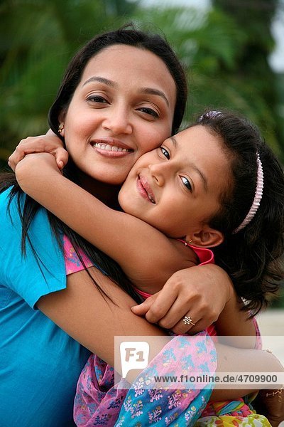 South Asian Indian mother and daughter hugging each other and smiling MR3687H687E