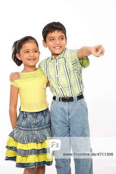 Brother kept his right hand on right shoulder of sister showing something by pointing his index finger MR703N 703O