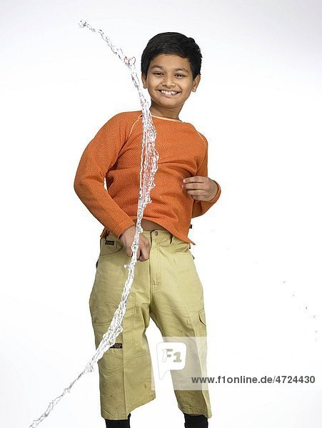 Water splashing on South Asian Indian boy in nursery school MR