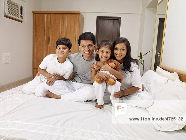 Parents with children sitting on bed in bedroom MR702R MR702S MR702T MR702U