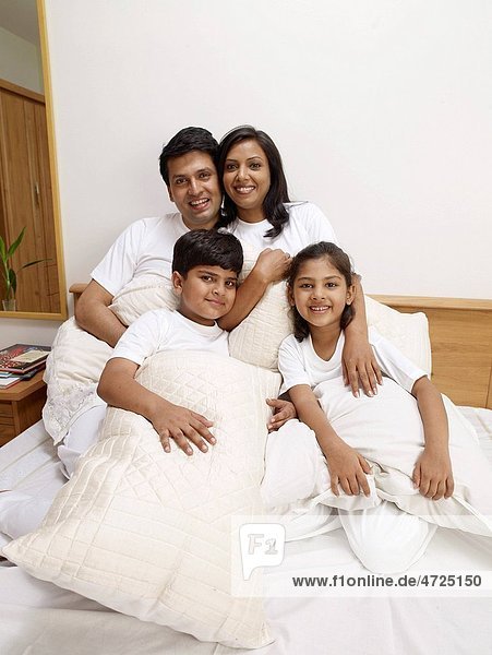 Children with parents holding pillows sitting on bed in bedroom MR702R MR702S MR702T MR702U