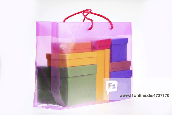 Clear plastic bag filled with colorful paper gift boxes
