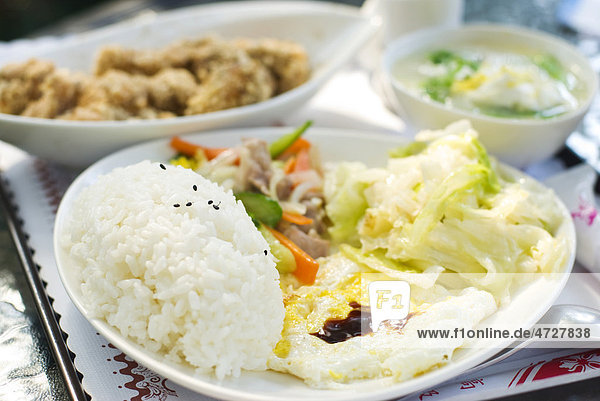 Chinesisches Essen mit Reis  Ei  Kohl  gebratenem Huhn und Suppe auf einem Tisch