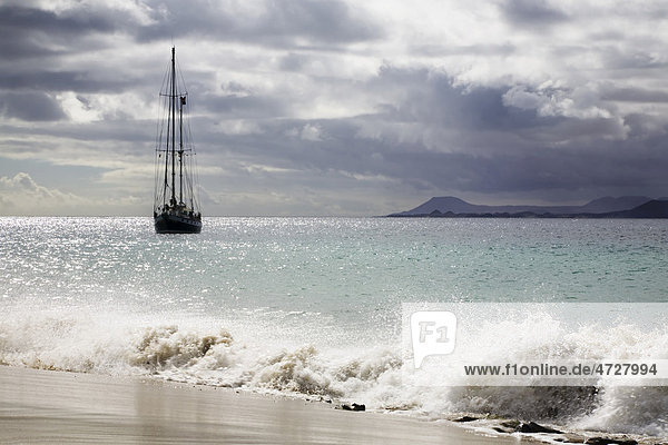 Segelboot an der Playa de Mujeres nahe Playa Blanca  hinten Fuerteventura  Lanzarote  Kanarische Inseln  Spanien  Europa