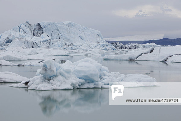 Eisberge spiegeln sich im ruhigen Gletschersee Jökulsarlon  Island  Europa