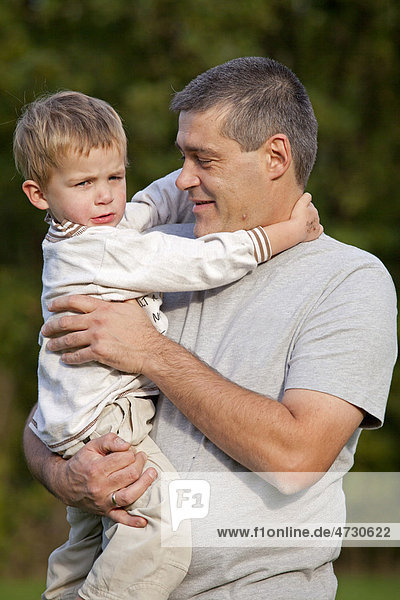 Vater trägt kleinen Sohn auf dem Arm