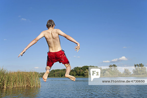 Junge springt von einem Steg in einen See  Teterow  Mecklenburg-Vorpommern  Deutschland  Europa