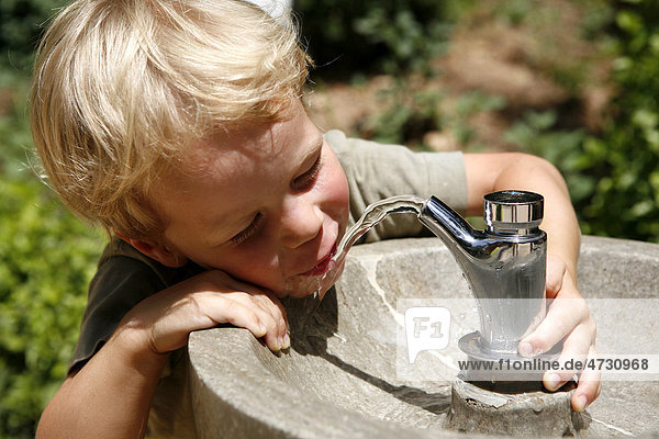 Boy  three years  drinking water from a public tap  Spain  Europe