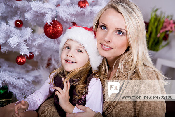 Mutter und Tochter am Weihnachtsbaum