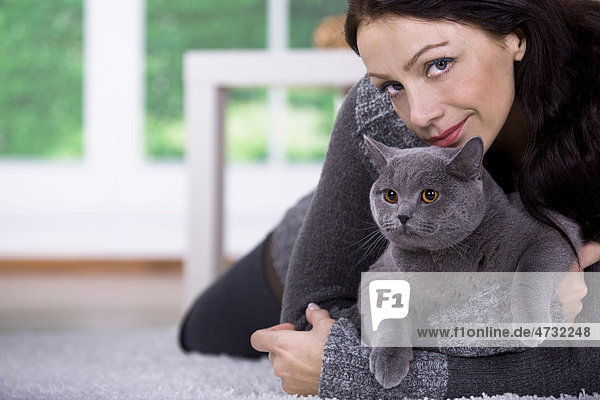 Junge Frau zu Hause mit einer Britischen Kurzhaar-Katze
