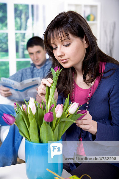 Junge Frau beim Anordnen von Tulpen in einer Vase