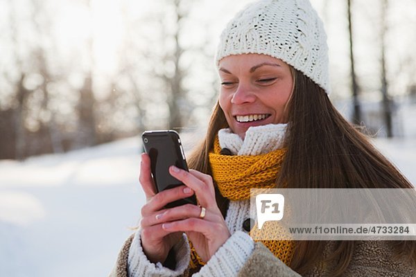 Portrait Mitte adult Lächelnde Frau mit Telefon-Telefon  winter