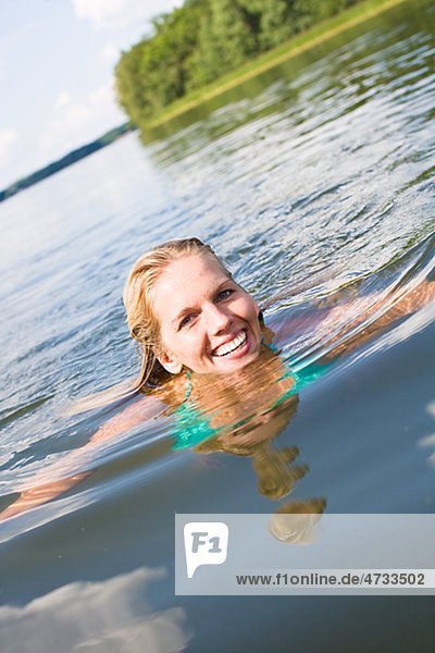 Young woman swimming in lake