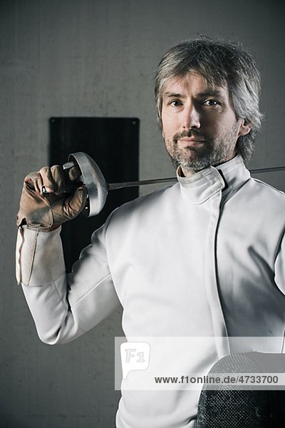 Portrait of male fencer in sports hall