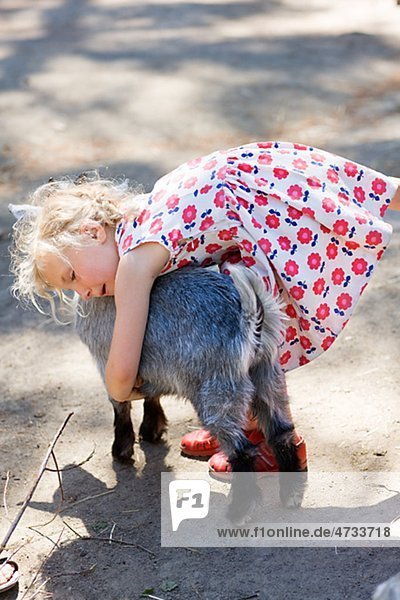Mädchen umarmen Ziege im zoo