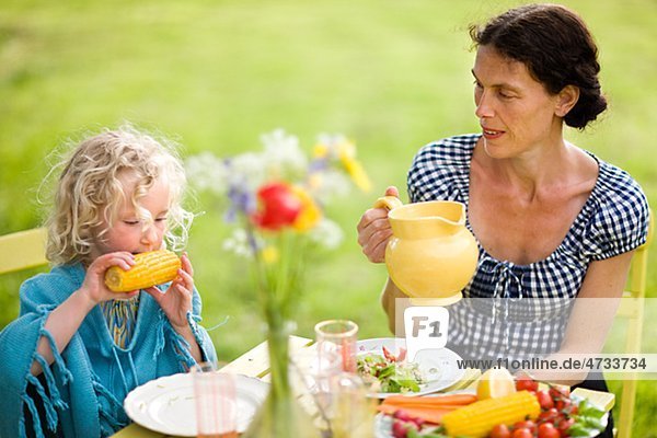 Außenaufnahme Tochter essen essend isst Mutter - Mensch freie Natur