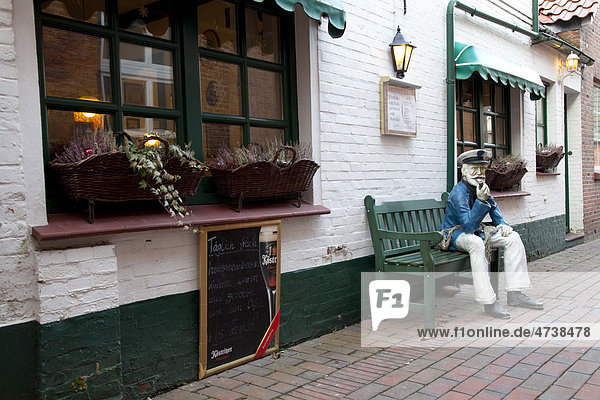 Restaurant and tea room with a seated sailor figure Greetsiel Krummhoern East Frisia Lower Saxony North Sea Germany Europe