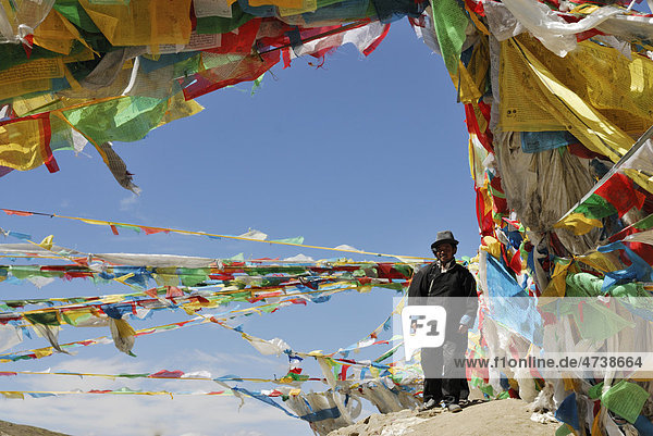 Tibeter inmitten von Gebetsfahnen  Tra La Pass  Friendship Highway zwischen Shigatse und Lhatse  Tibet  China  Asien