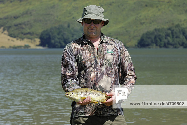 Fischer mit Forelle (Salmo trutta) am Diamond Lake bei Glenorchy  Südinsel  Neuseeland