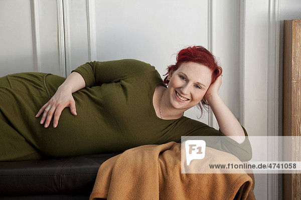 Schwangere Frau ruht sich aus und hält den Babybauch