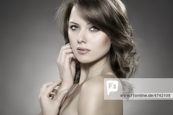Junge Frau die ihre Hand an die Wange schmiegt  Beautyportrait