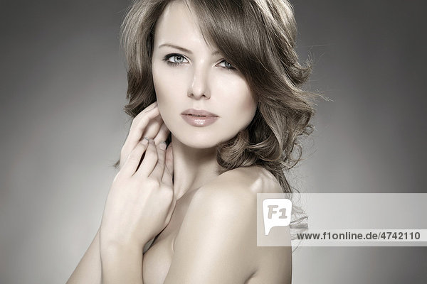 Young woman holding her hands next to her cheek  beauty shot  portrait