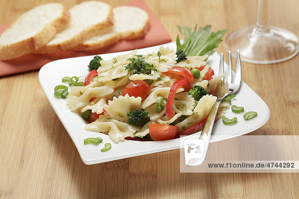Farfalle Nudelsalat mit Paprika  Brokkoli  Tomaten  Erbsen und Lauchzwiebeln  Weißbrotscheiben