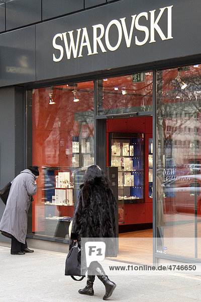 Eine Frau betrachtet die Auslage im Schaufenster von dem führenden Hersteller von geschliffenem Kristall  Swarovski  auf der Einkaufsmeile Königsallee  Kö  Düsseldorf  Nordrhein-Westfalen  Deutschland  Europa
