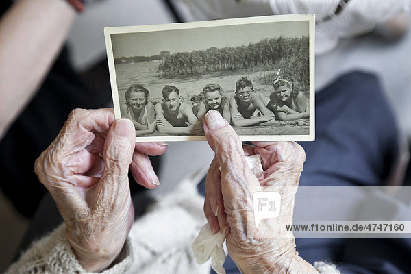 Bildbetrachtung  alte Damenhände halten ein historisches Erinnerungsfoto aus den vierziger Jahren  Altenheim  Seniorenheim  Berlin  Deutschland  Europa