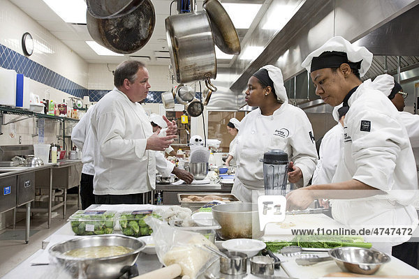 Ausbilder John Adamski erklärt einem Schüler wie man Speisen zubereitet  an der Dorsey Culinary Academy  eine private Einrichtung an der man eine Berufsausbildung absolvieren kann  Roseville  Michigan  USA