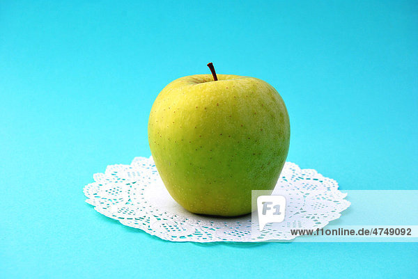 Grüner Delicious Apfel auf Tortendeckchen aus Papier