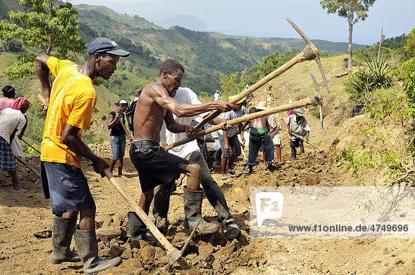 Inhabitants of a mountain village building a road with the assistance of an aid organisation  they want to link their village to the main road to allow economic development in the community  Bordes  Leogane  Ouest Department  Haiti  Caribbean  Central America