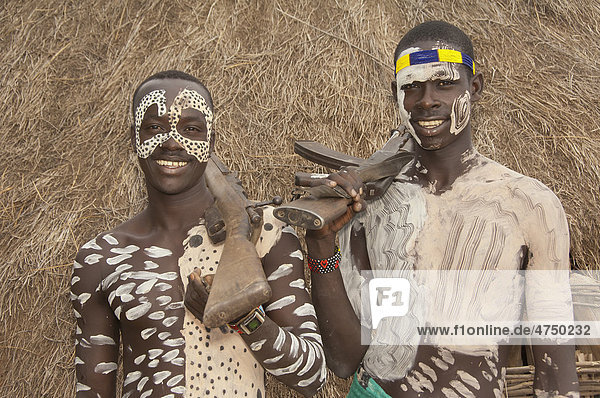 Zwei Karo Krieger mit Körperbemalung und Gesichtsbemalung und einem Gewehr auf der Schulter  Omo Tal  Äthiopien  Afrika
