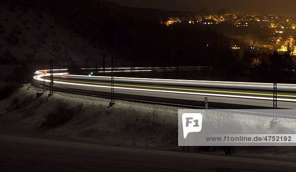 Light trace of a train in winter at night  Beimerstetten  Baden-Wuerttemberg  Germany  Europe