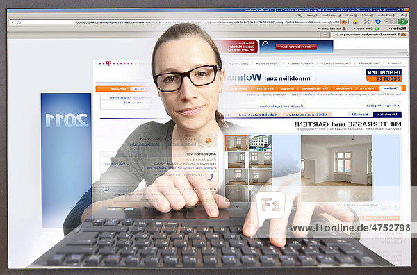 Junge Frau am Computer  surft im Internet  auf ImmobilienScout24.de  Blick aus dem Computer  Symbolbild