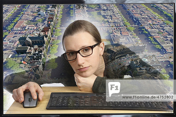 Junge Frau sitzt am Computer  arbeitet mit Google Street View  Detailbild von einem Teil der Innenstadt von Amsterdam  Personen und KFZ-Kennzeichen sind unkenntlich gemacht worden  Blick aus Computer  Symbobild