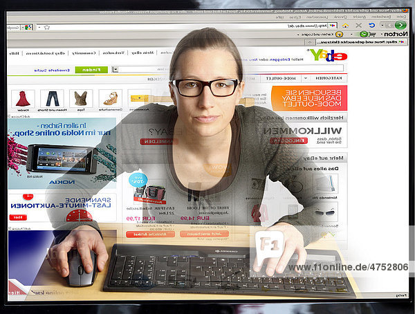 Junge Frau sitzt am Computer  surft im Internet  auf der Seite des Internet Auktionshauses EBAY  Blick aus dem Computer  Symbolbild
