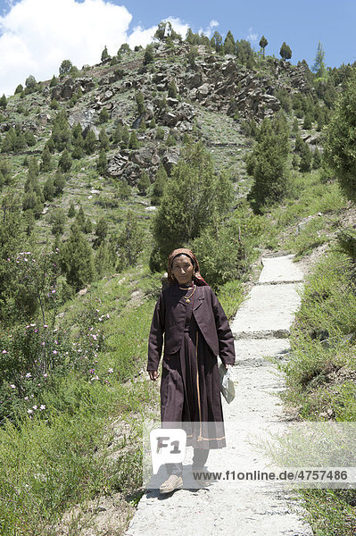 Frau in Tracht geht auf dem Pfad hinunter vom Kloster Shashur Gompa  Keylong  Distrikt Lahaul und Spiti  Bundesstaat Himachal Pradesh  Indien  Südasien  Asien