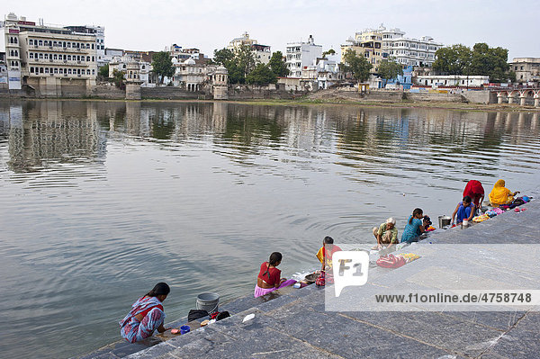 Indische Frauen waschen am Ufer  Ghat  des Pichola-See ihre Wäsche  Udaipur  Rajasthan  Indien  Asien