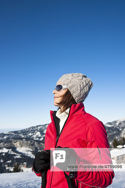 Lächelnde Frau mit Skistöcken in Winterlandschaft  Tannheimer Tal  Tirol  Österreich