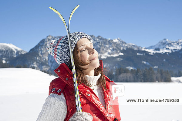 Frau mit Skiern in Winterlandschaft  Tannheimer Tal  Tirol  Österreich