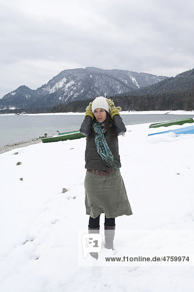 Young woman on the lakeshore of Walchensee or Lake Walchen  winter  coldness  Bavaria  Germany  Europe