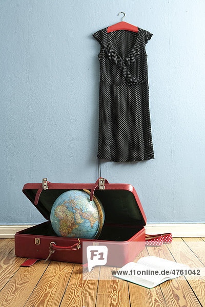 Globus im Koffer  Kleid auf Kleiderbügel  Buch  Symbolbild Reise  Urlaub  Weltreise