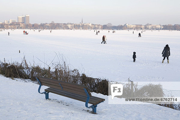 Walkers on the frozen outer Alster lake in the evening  Hamburg  Germany  Europe