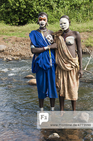 Zwei junge Surma Frauen mit Gesichtsbemalung und Körperbemalung am Fluss  Kibish  Omo-Tal  Äthiopien  Afrika