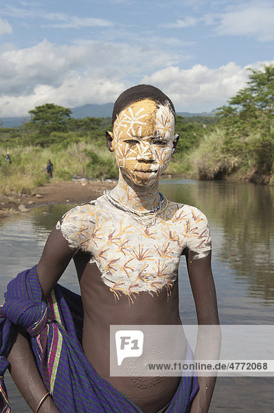 Surma boy with facial and body painting in the river  Kibish  Omo River Valley  Ethiopia  Africa
